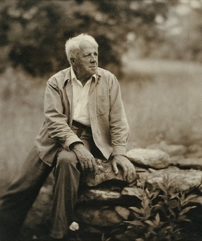 Photograph of Robert Frost sitting on a rock.