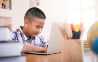 Boy using his laptop to learn online.