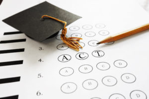 ACT college entrance test with pencil and graduation cap