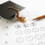 ACT college entrance test with pencil and graduation cap
