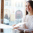 Picture of a teen handing her resume to her interviewer in a cafe for a college admissions interview
