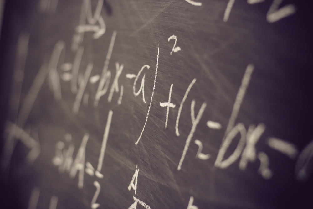 Maths formulas written by white chalk on the blackboard background.
