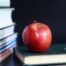 A stack of back to school books and an apple