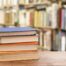 stack of books for sat and act prep in a library