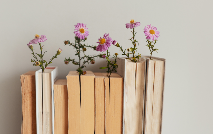 Poetry books standing up against a wall, decorated with pink, springtime flowers to celebrate national poetry month